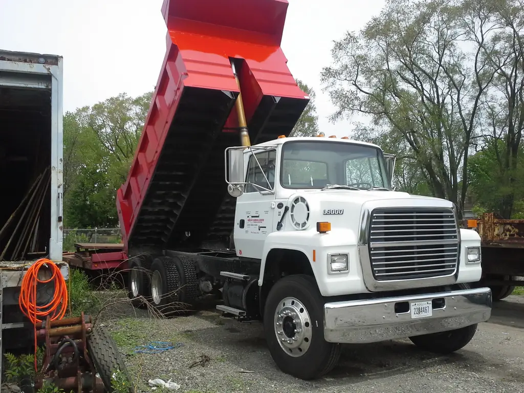 An Area Plumbing & Sewer dump truck with its bed raised in the Hammond yard